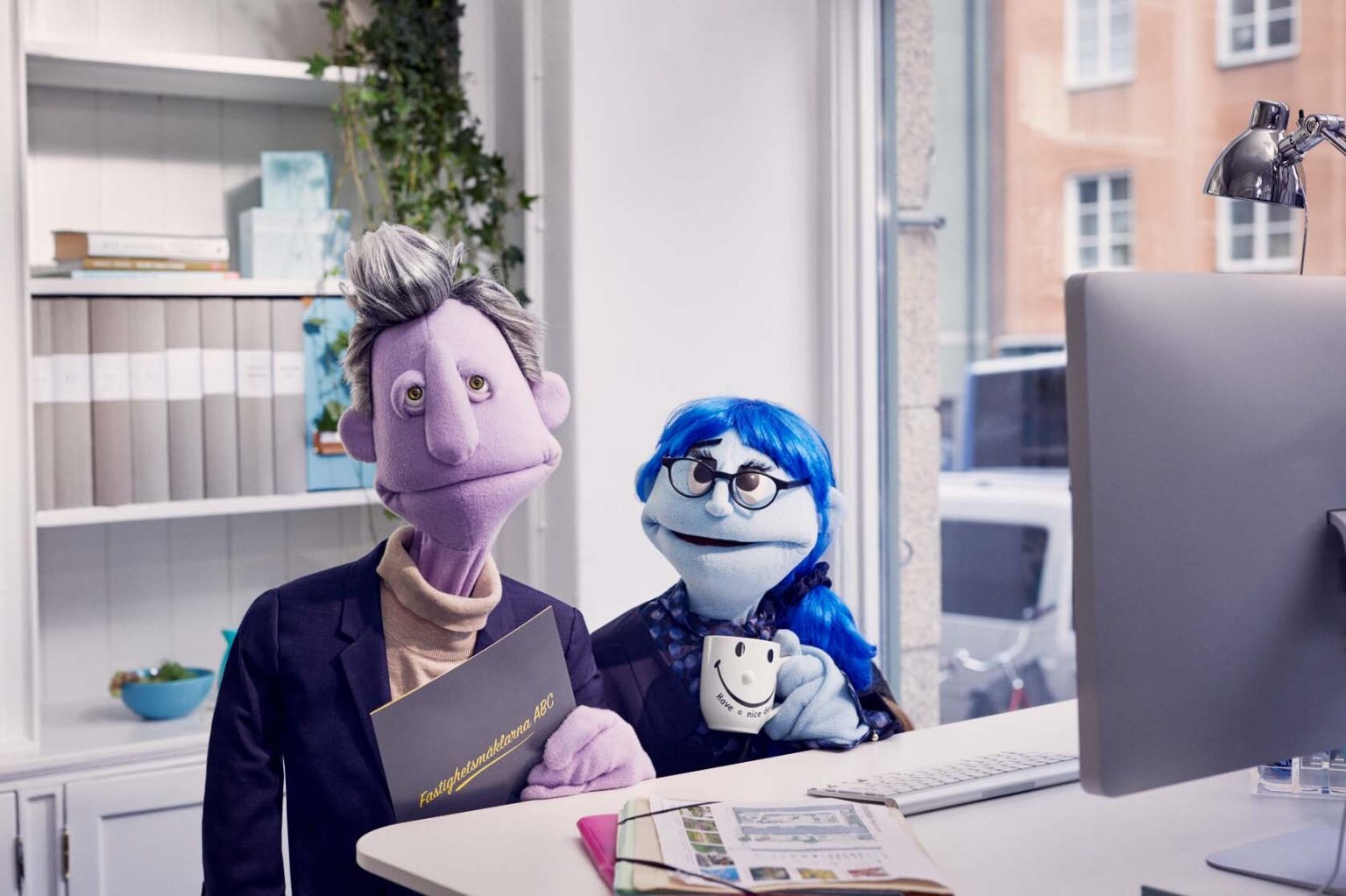 two puppets sitting at a desk