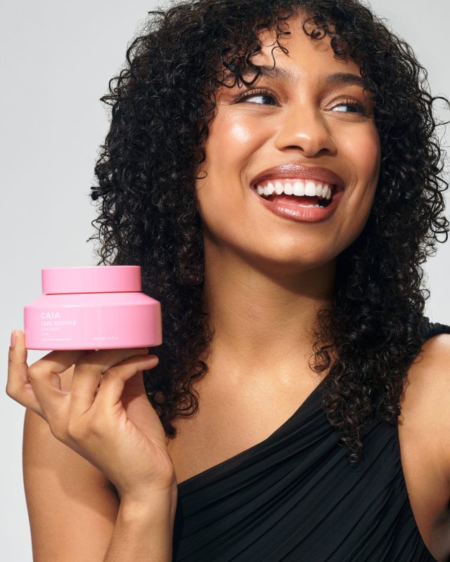 a woman holding a pink container