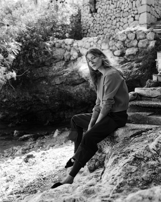 a woman sitting on a rock ledge