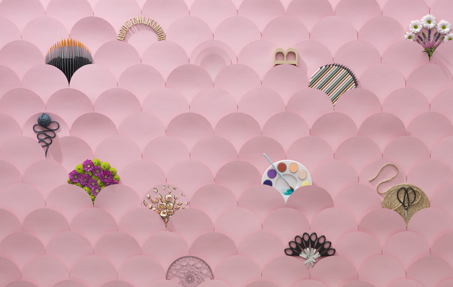 a pink wall with paper cutouts and flowers
