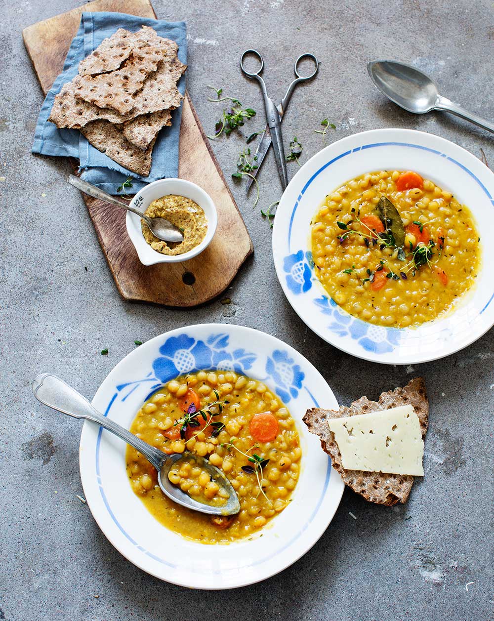 a plate of soup with spoons and bread