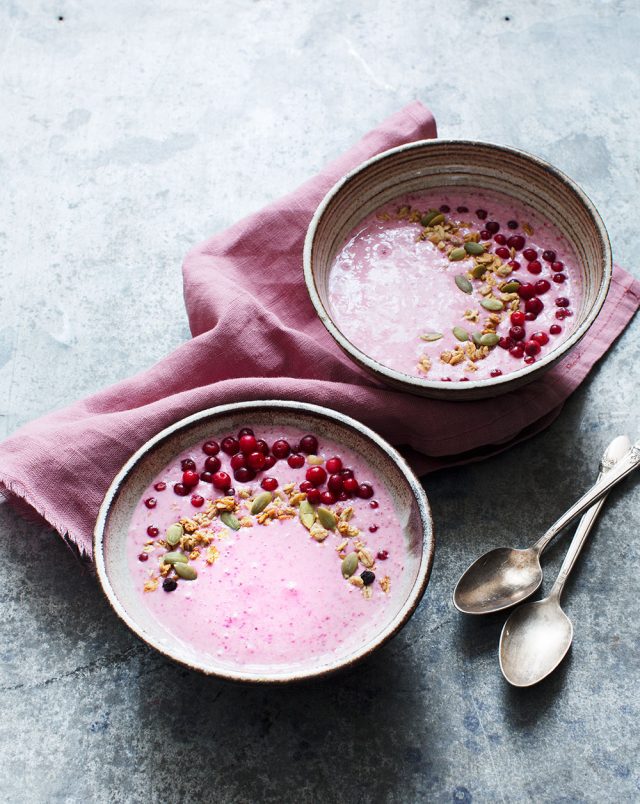 two bowls of food with spoons and a napkin