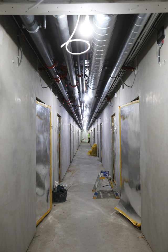 a long hallway with pipes and lights