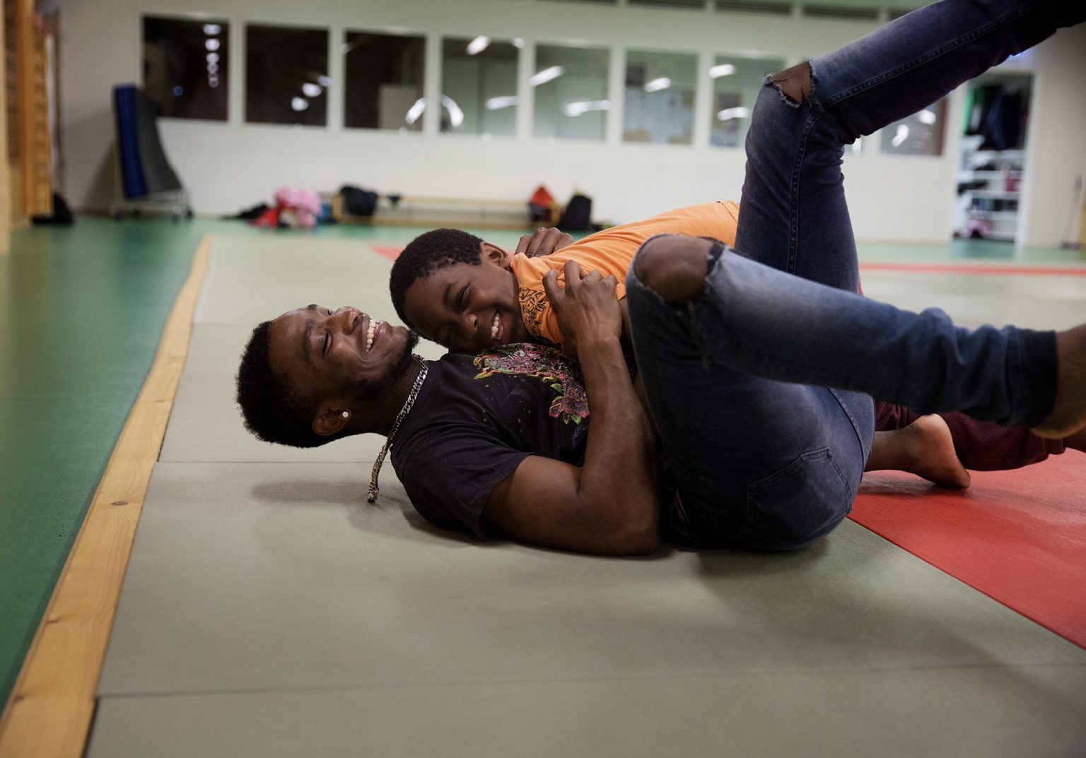 a man lying on the ground with another man in his arms