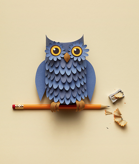 a paper owl sitting on a pencil