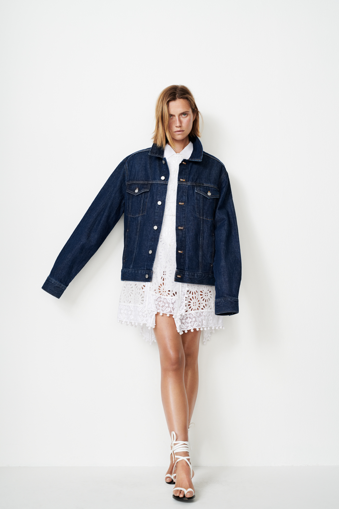 a woman in a white dress and denim jacket