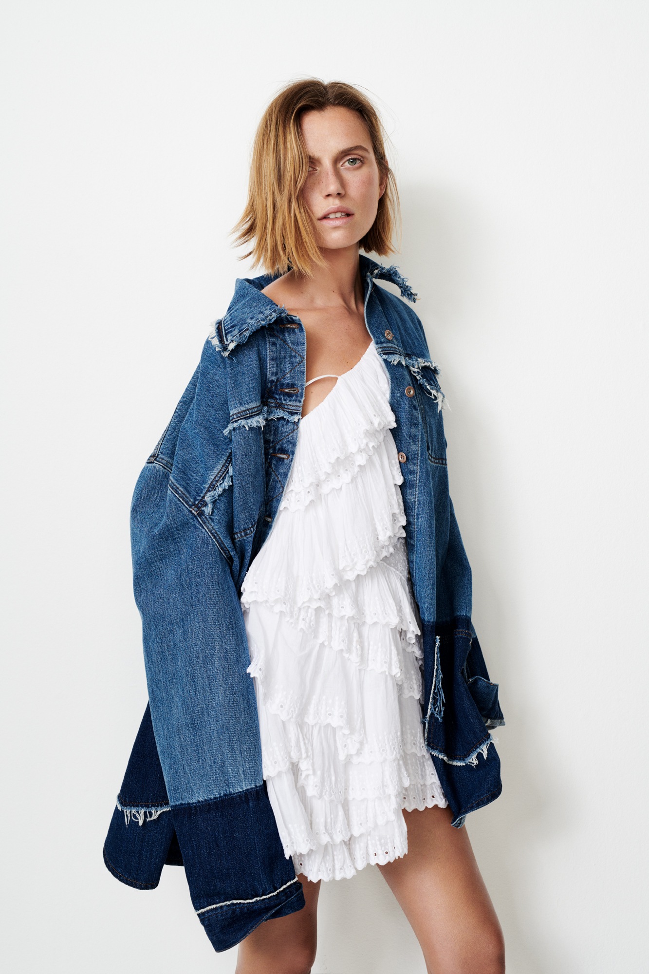 a woman in a white dress and denim jacket