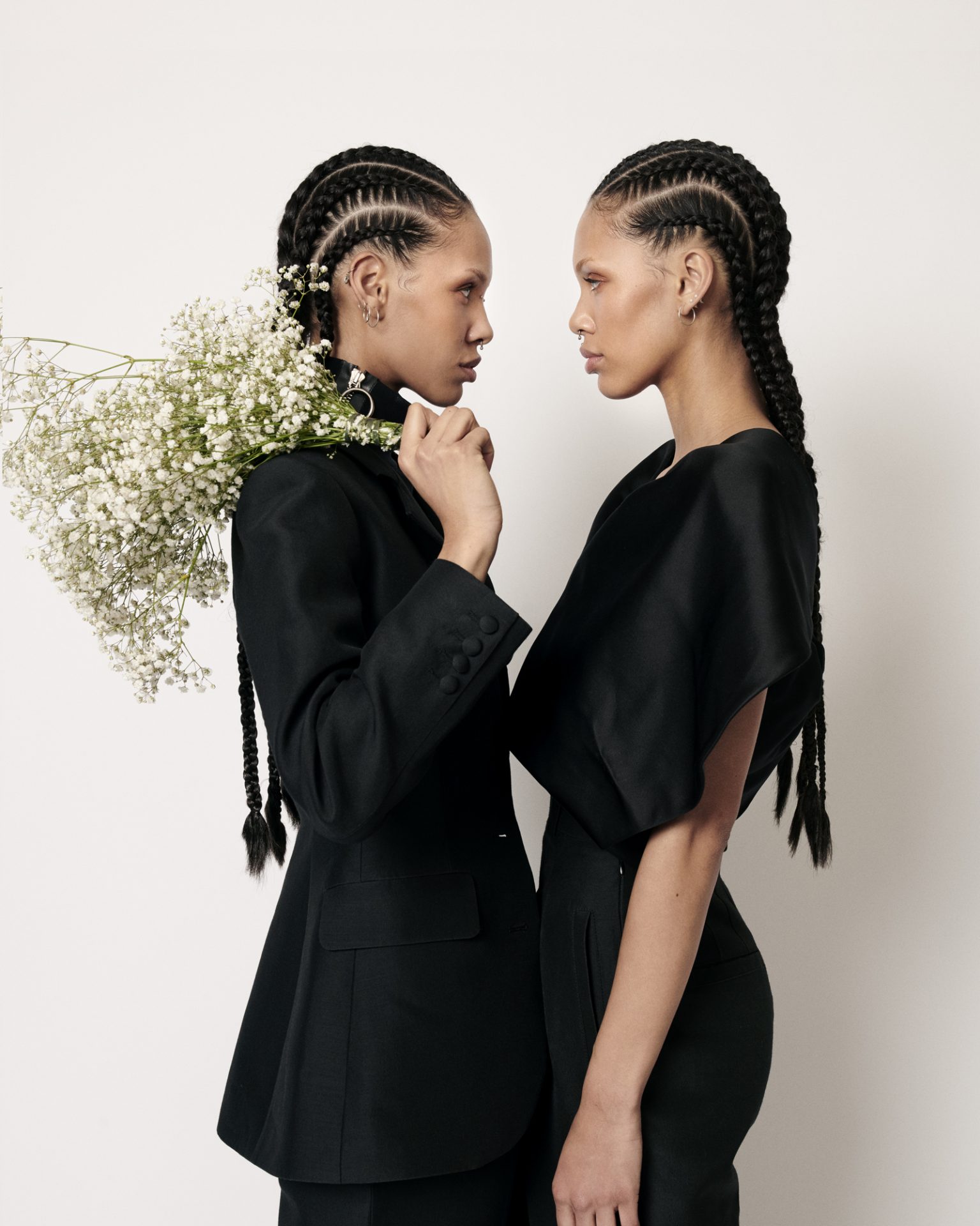 two women in black dresses holding flowers