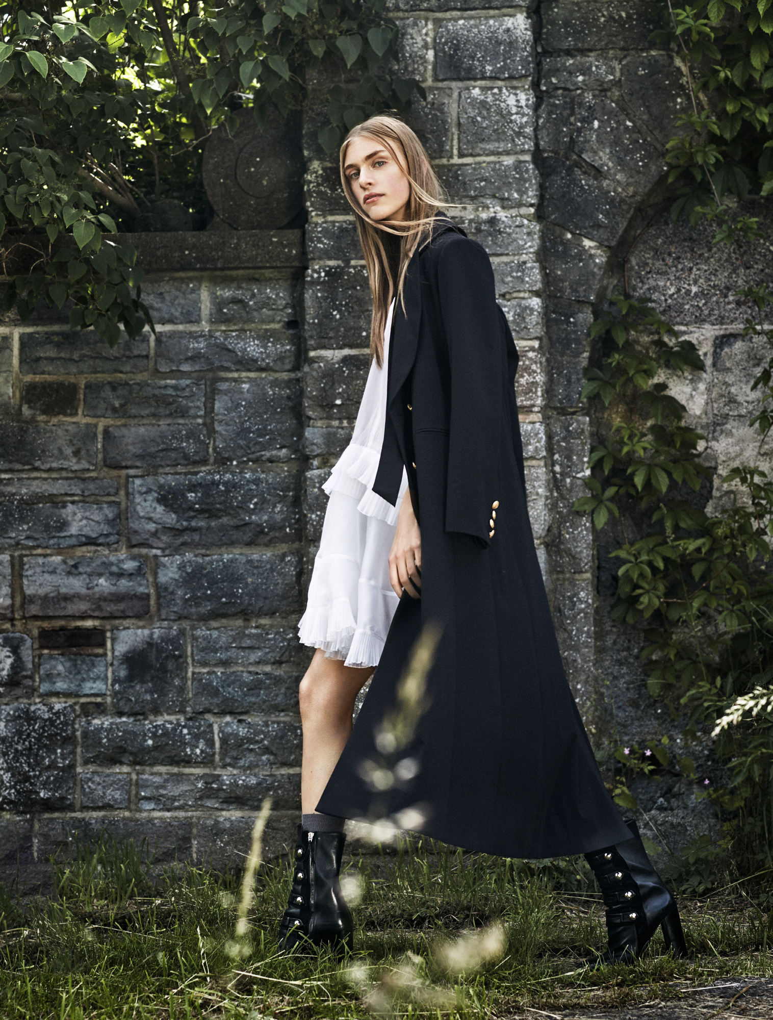 a woman in a long black coat and white dress