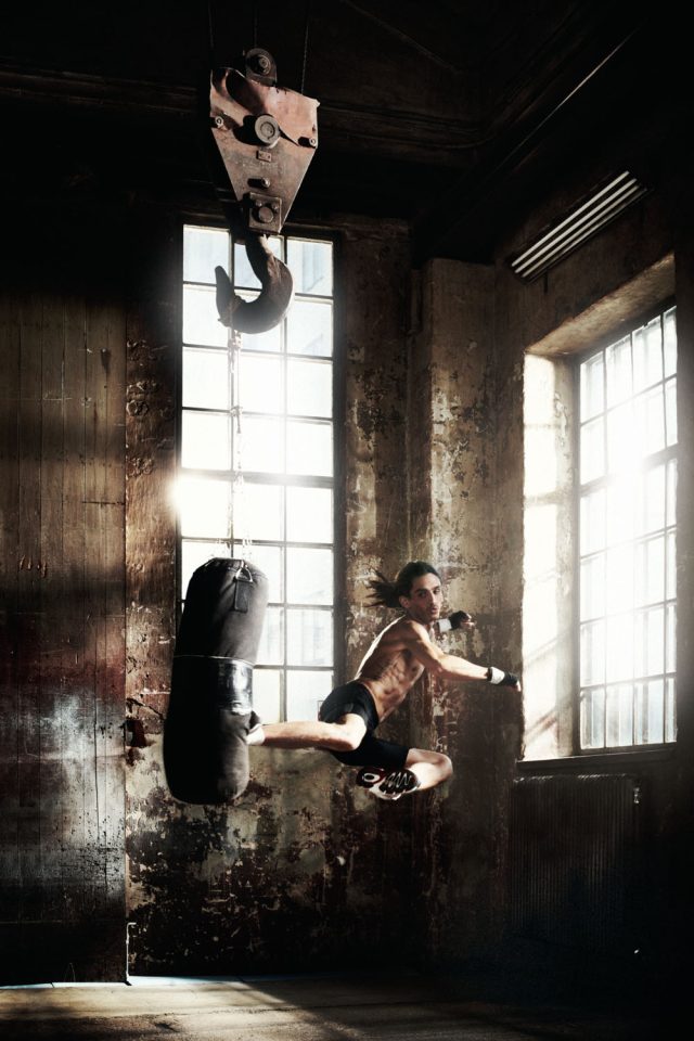 a man kicking a punching bag in a room