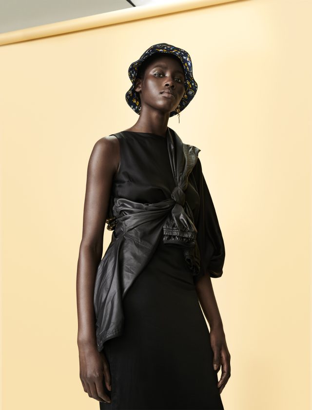 a woman in a black dress and hat