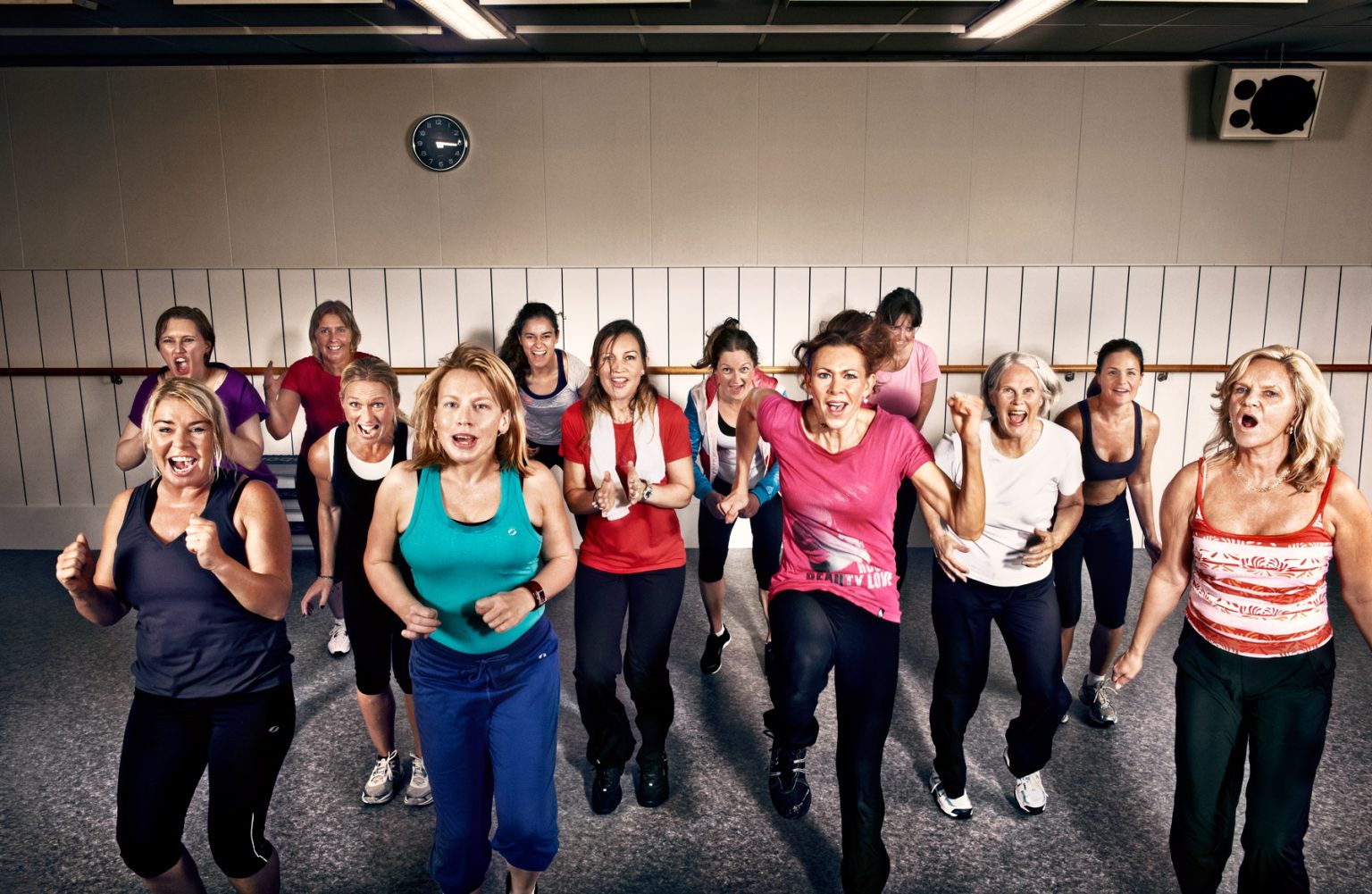 a group of women running in a gym