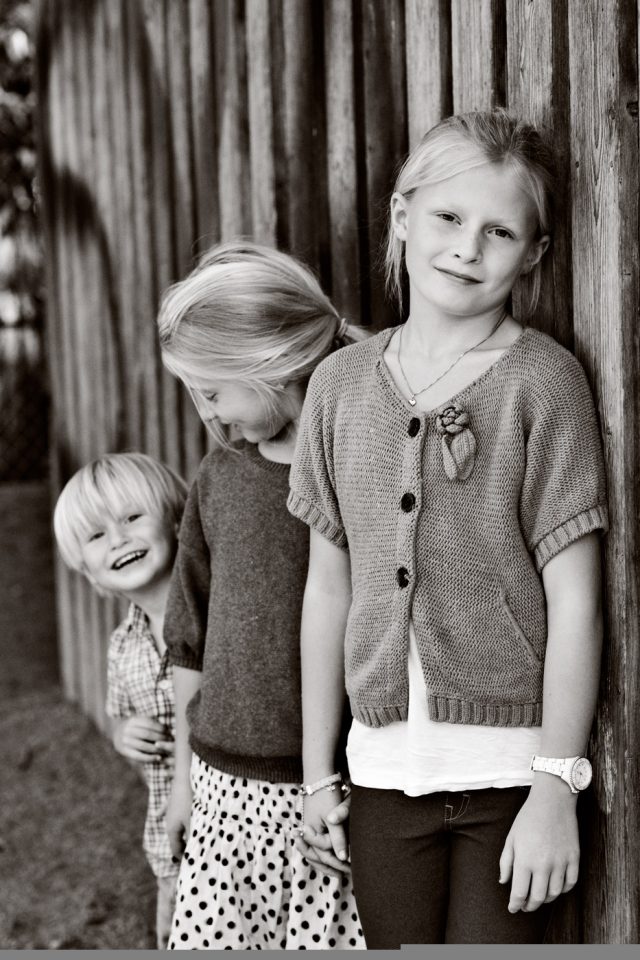 a group of children standing next to a wooden wall
