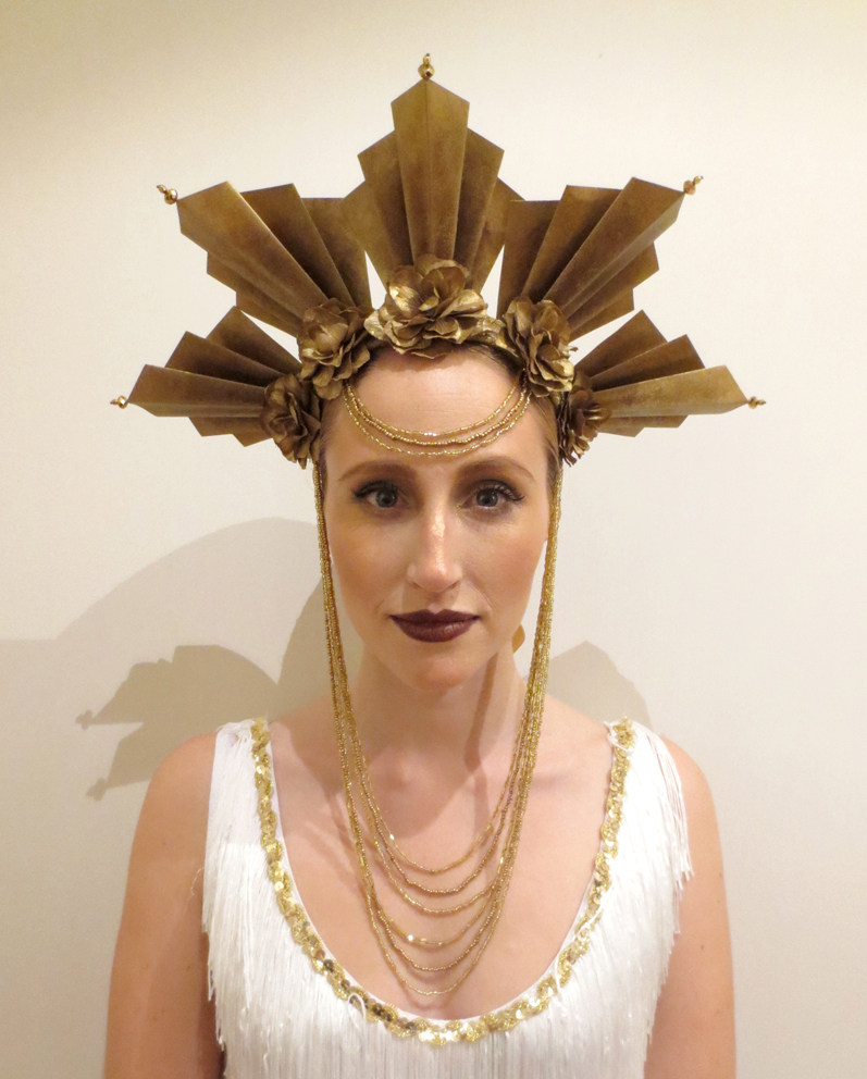 a woman wearing a gold crown and necklace
