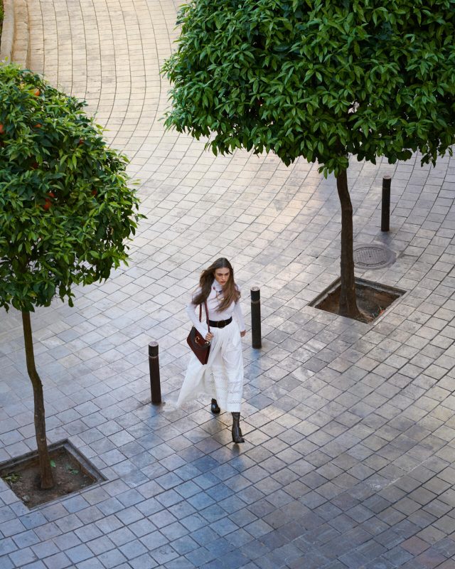 a woman walking on a brick walkway