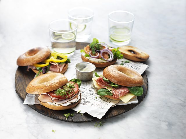 a plate of bagels with different toppings