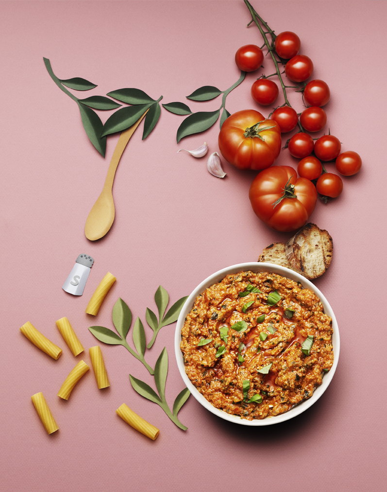 a bowl of food next to tomatoes and pasta