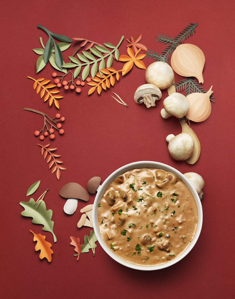 a bowl of soup next to mushrooms and paper cutouts