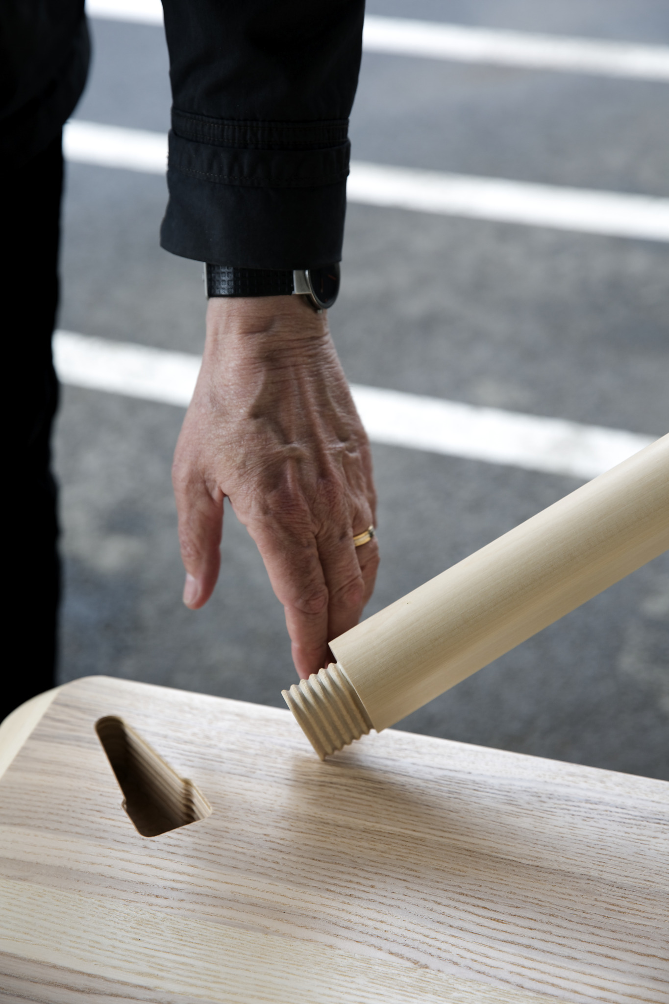 a hand touching a wooden piece of wood