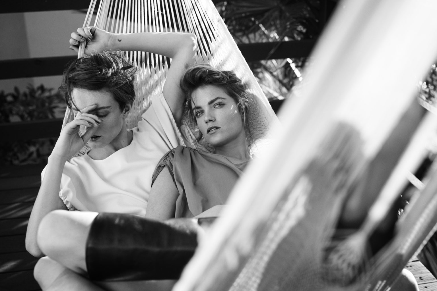 a couple of women sitting in a hammock