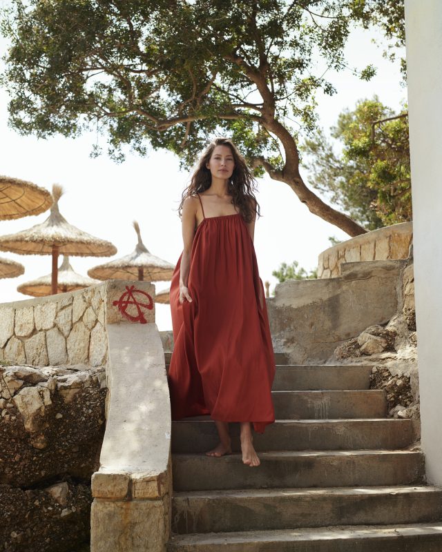 a woman in a red dress standing on stairs