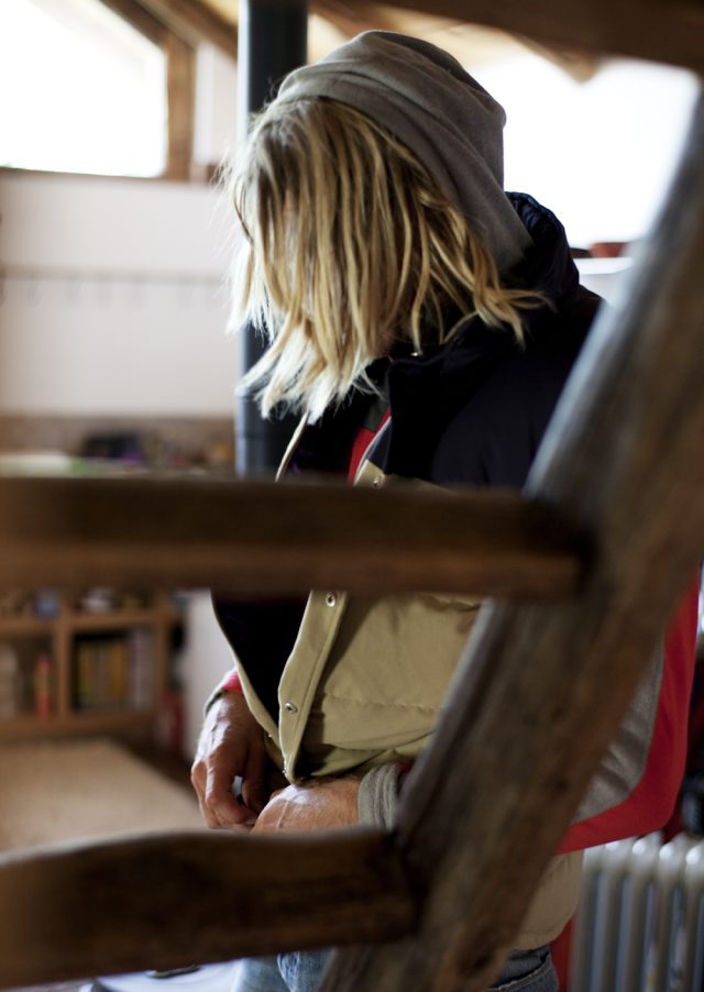 a person with long hair wearing a hoodie and jacket