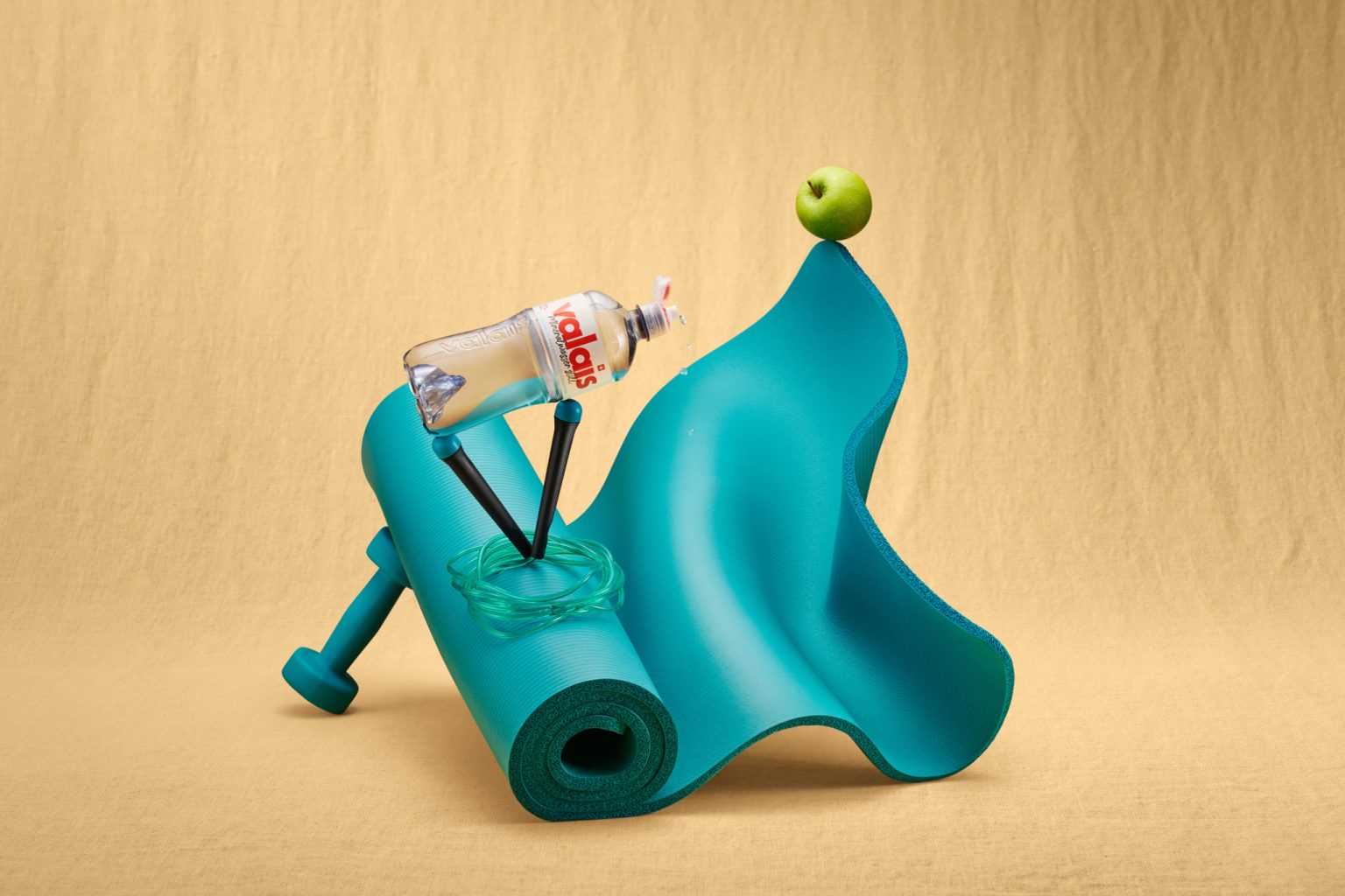 a yoga mat and a bottle of water on top of a green apple