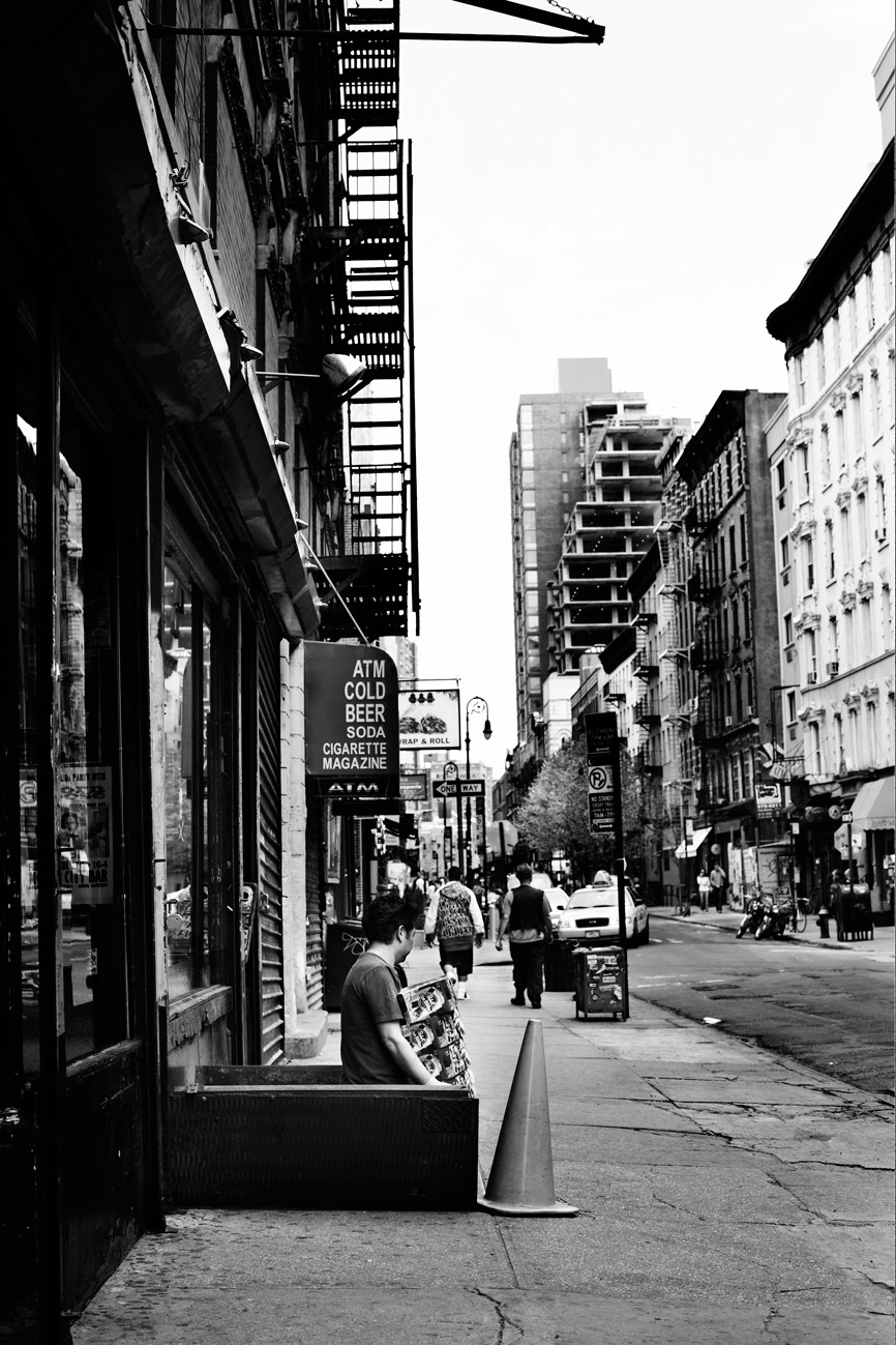 a man sitting on a bench in a city