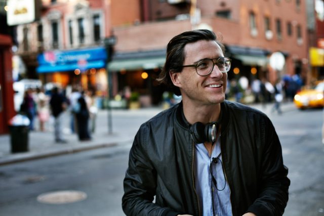 a man wearing glasses and a black jacket
