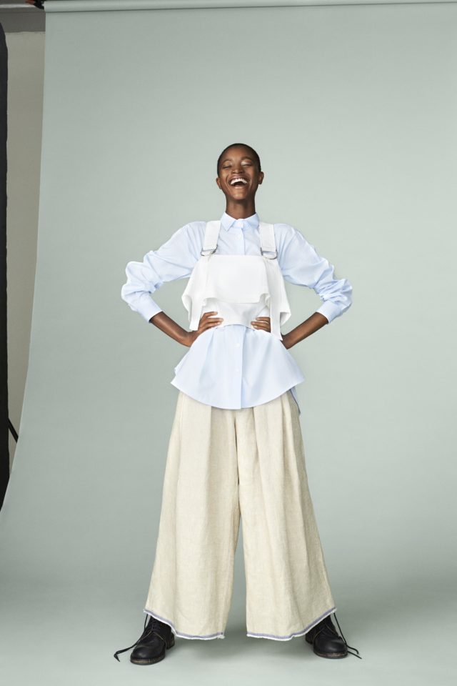 a woman wearing a white overalls and a blue shirt