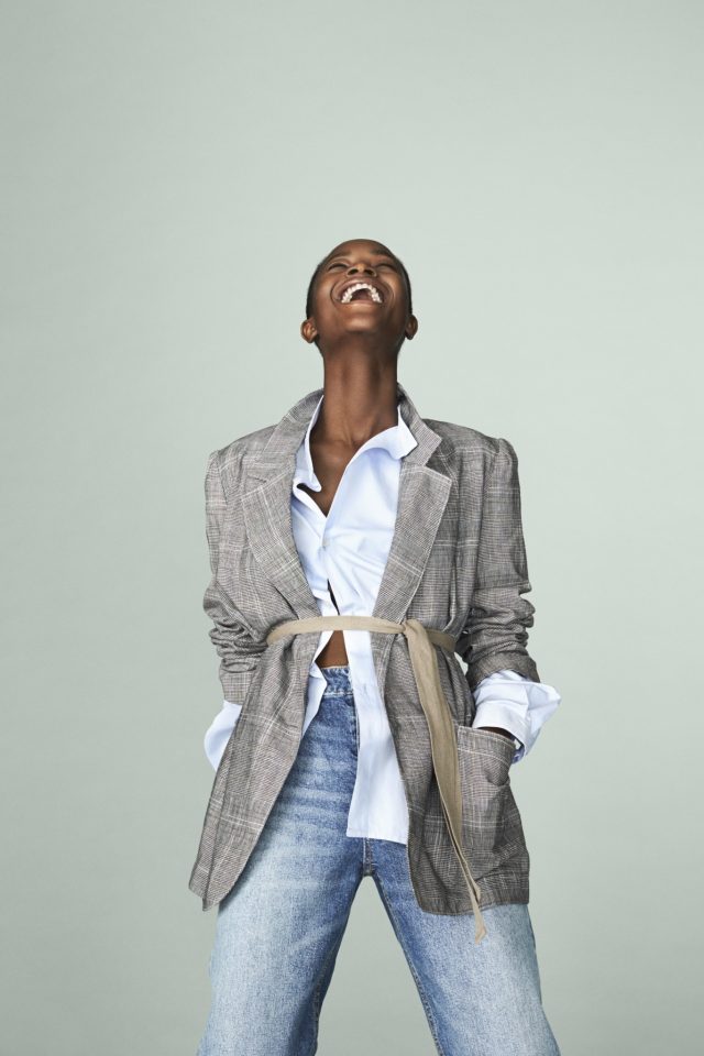 a woman in a grey coat laughing
