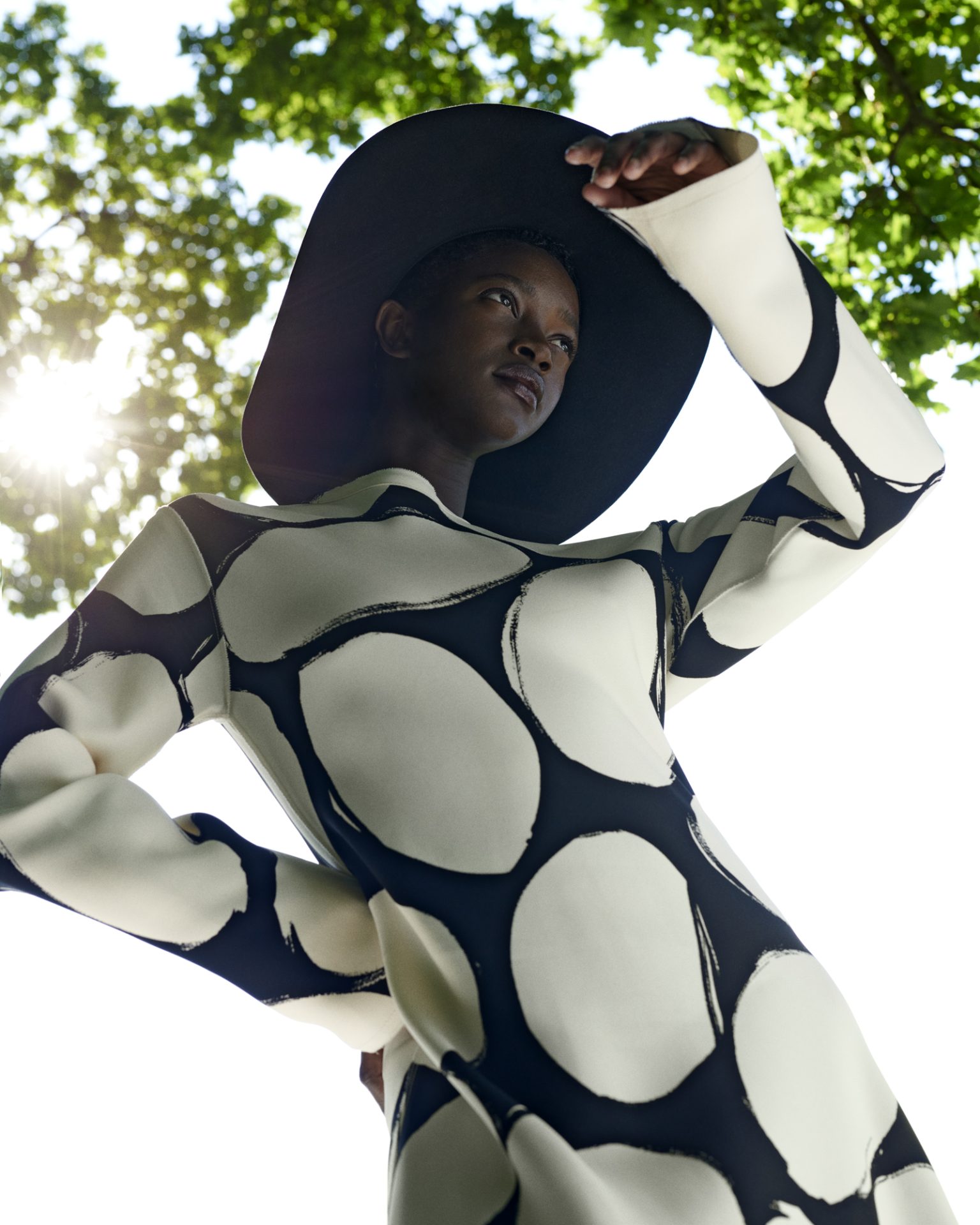 a woman wearing a black and white dress and hat