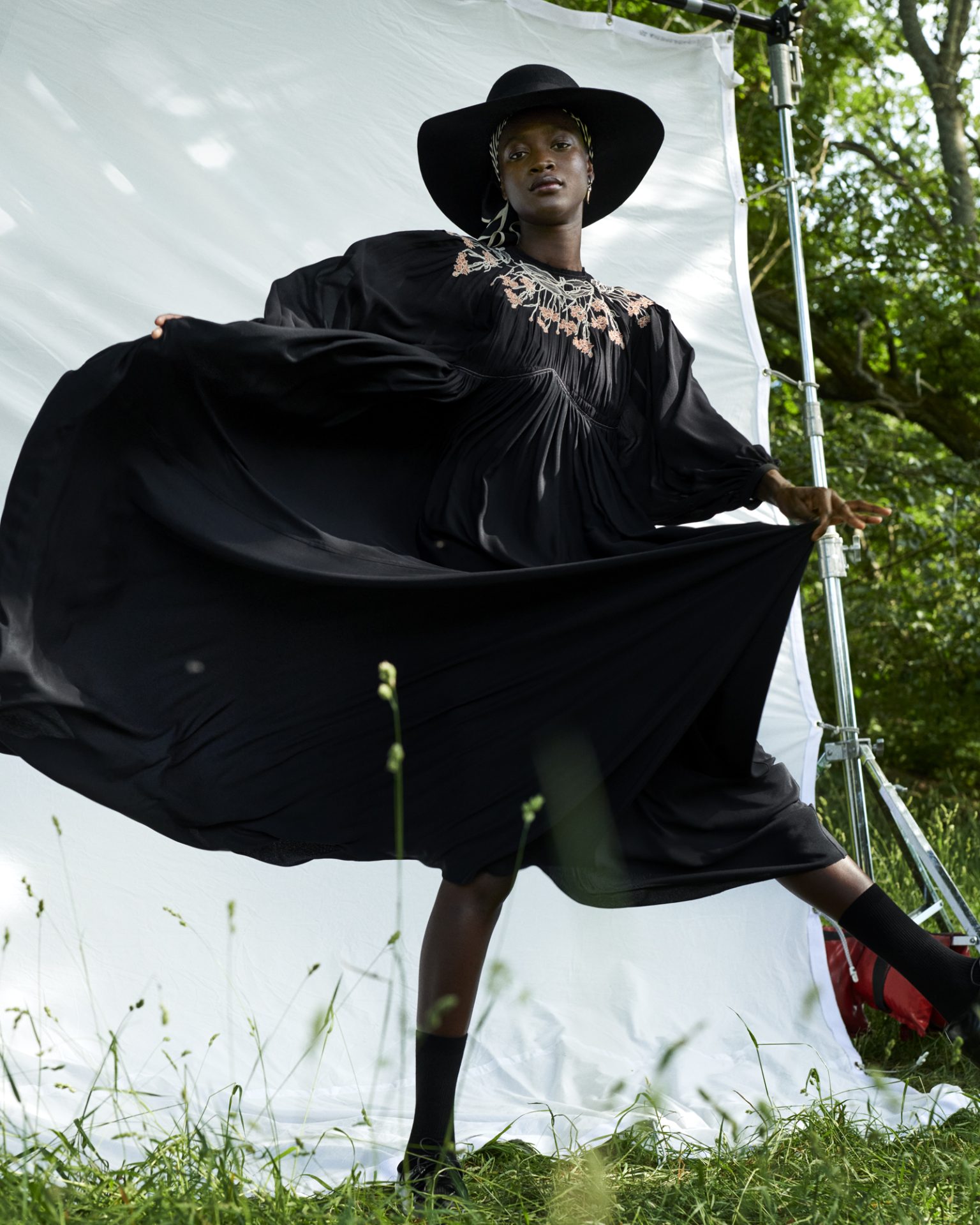 a woman in a black dress and hat