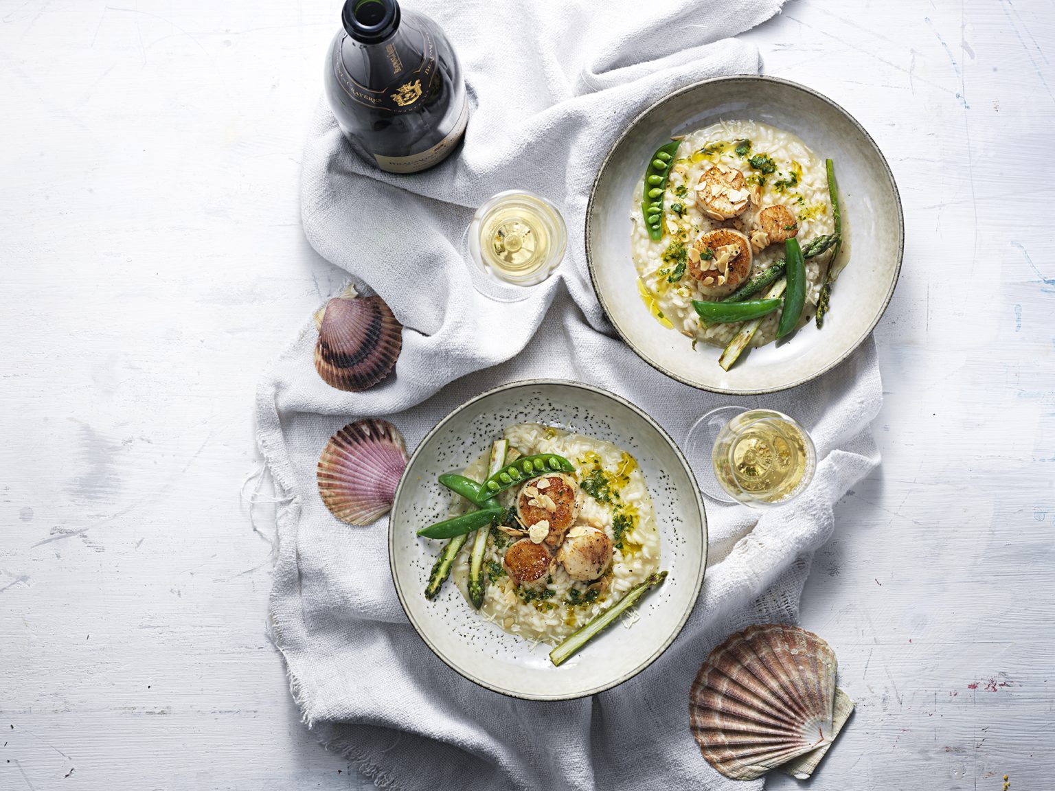 two plates of food on a white cloth