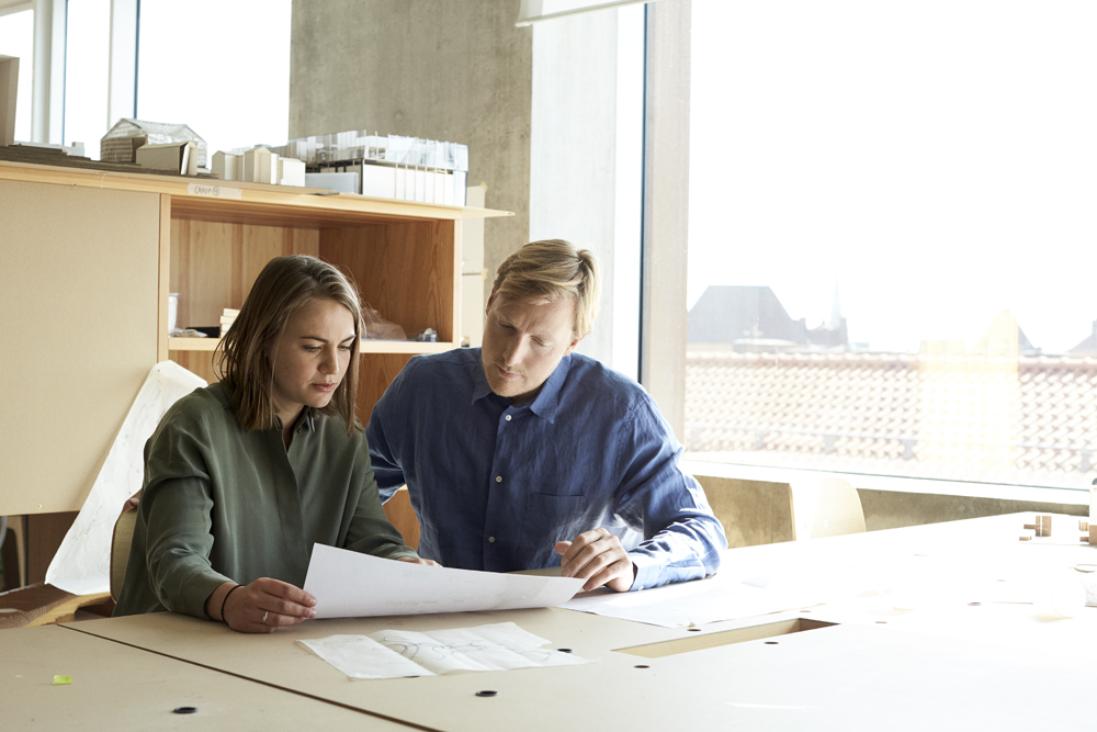 a man and woman looking at a piece of paper