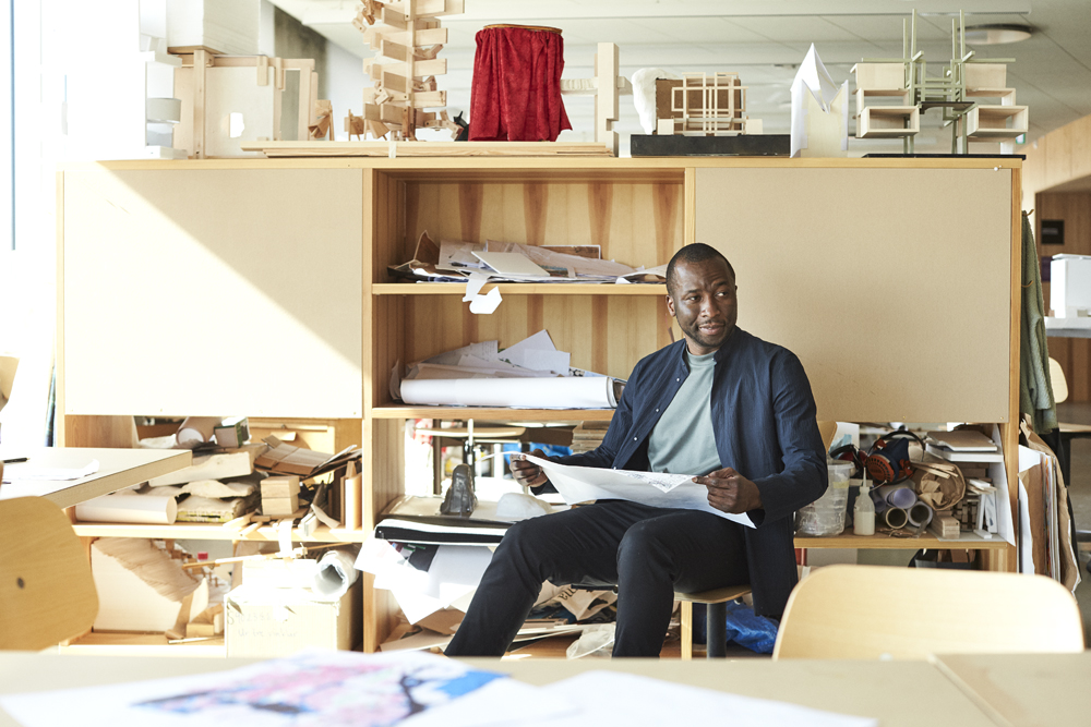 a man sitting on a chair holding a paper