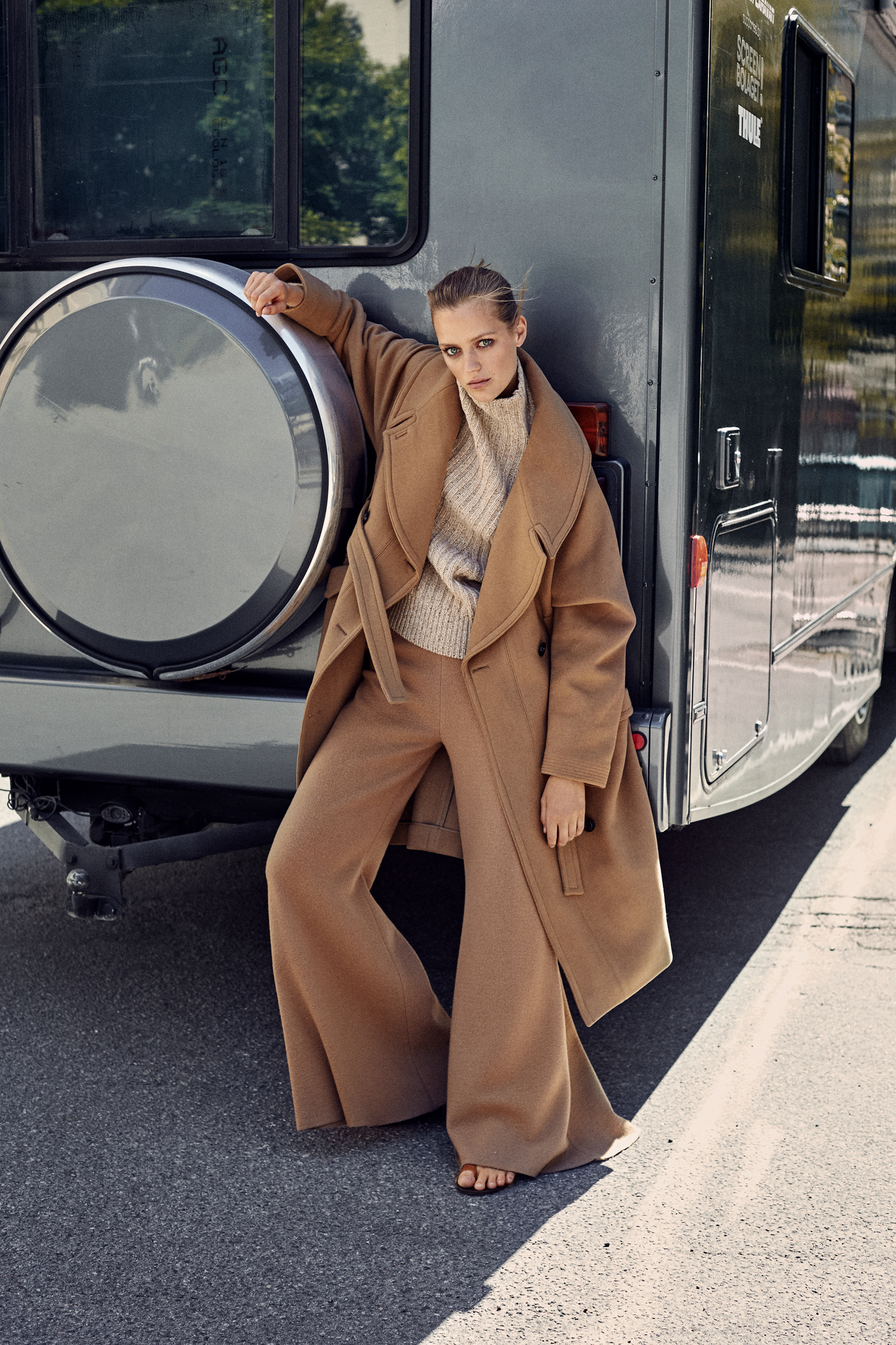 a woman leaning against a vehicle