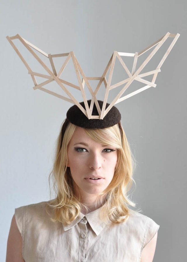 a woman wearing a hat with a wooden object on her head