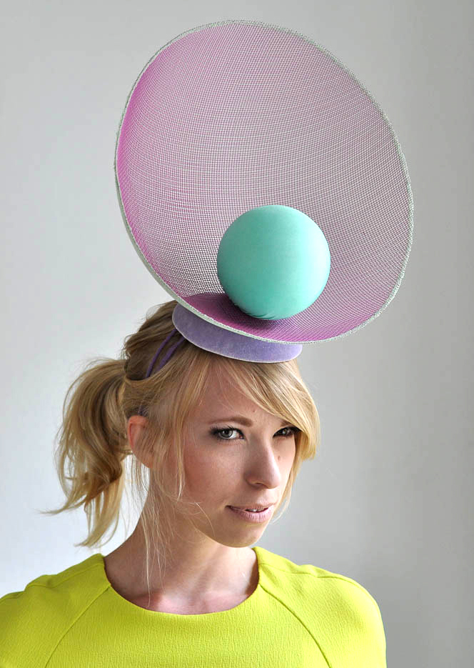 a woman wearing a hat with a ball on her head
