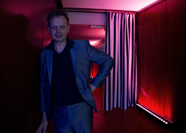 a man standing in a hallway with red light