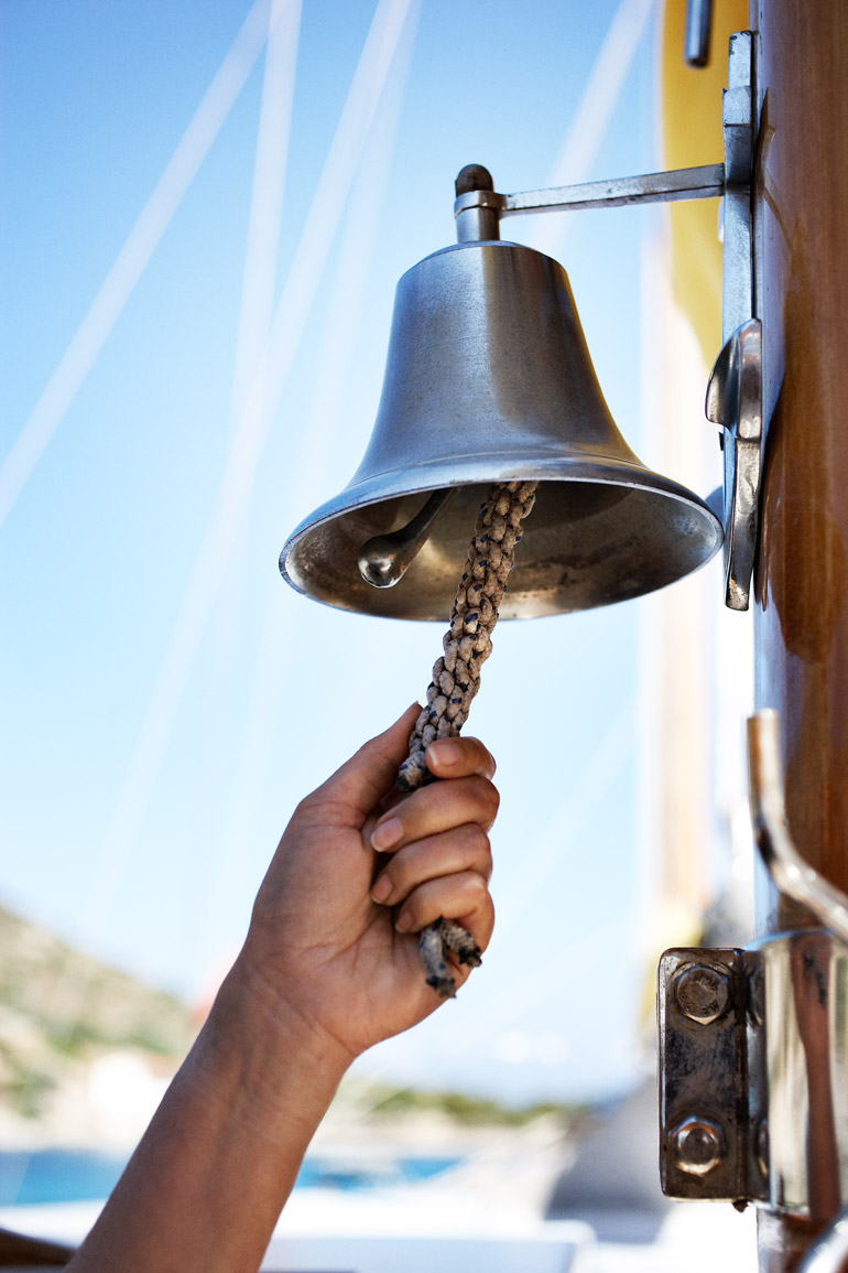 a hand holding a rope and a bell