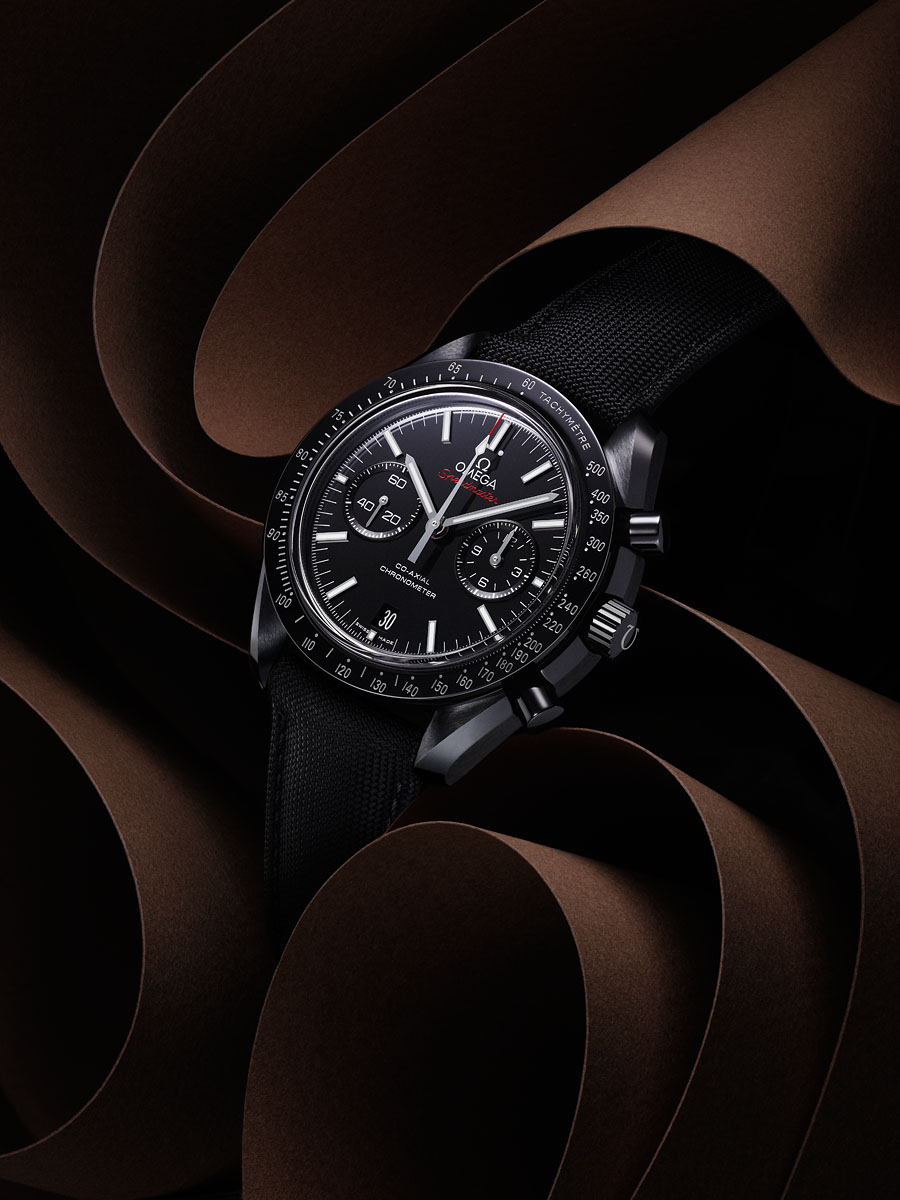 a black watch with a black band on a brown background