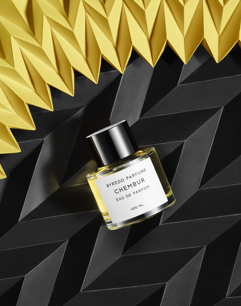 a bottle of perfume on a black and yellow background