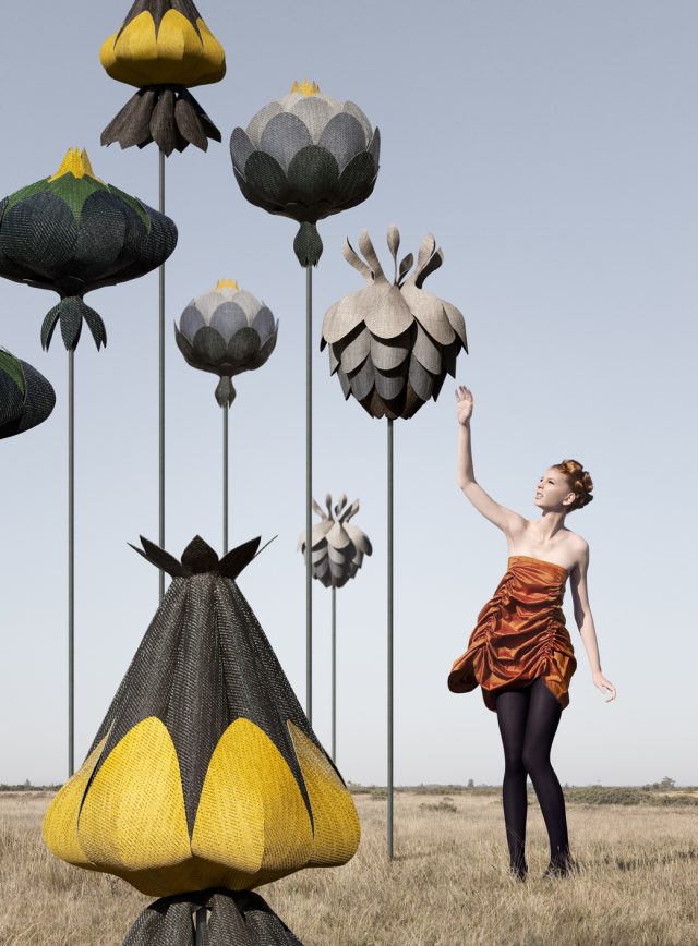 a woman in a dress touching a flower shaped object
