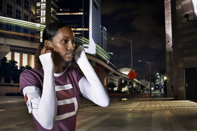 a woman wearing earphones on a street