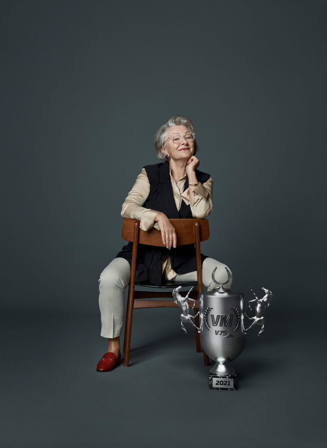 a woman sitting in a chair with a trophy