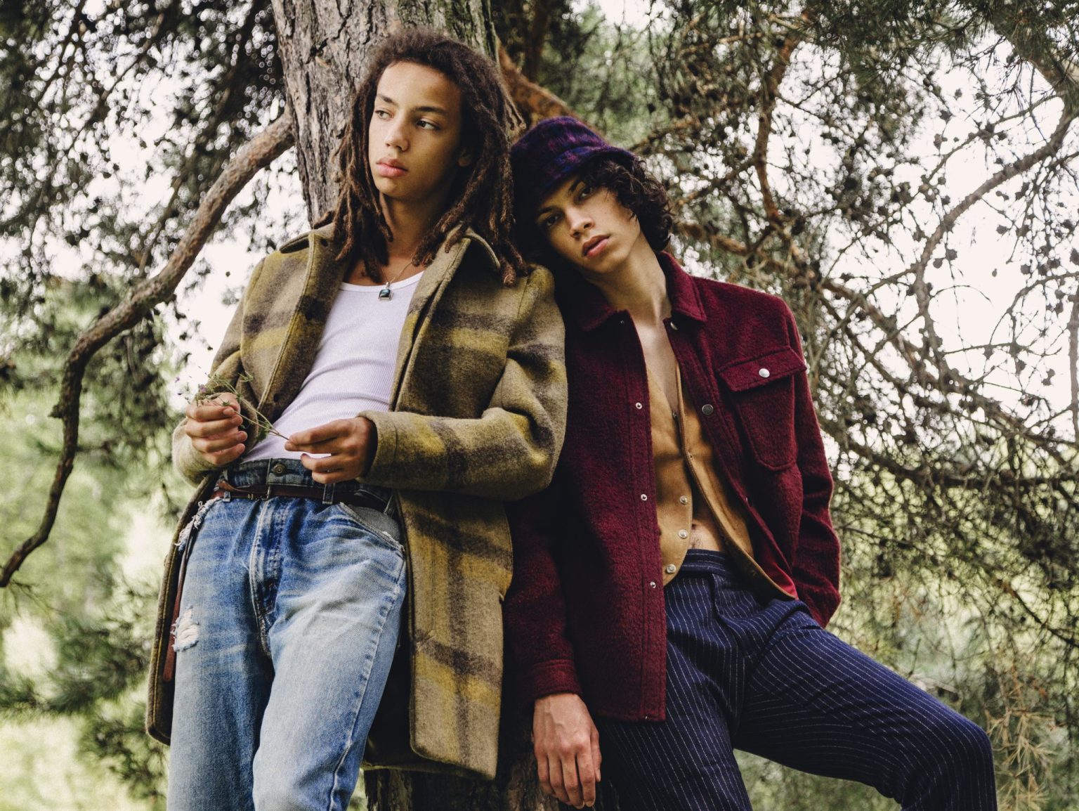 two men leaning against a tree