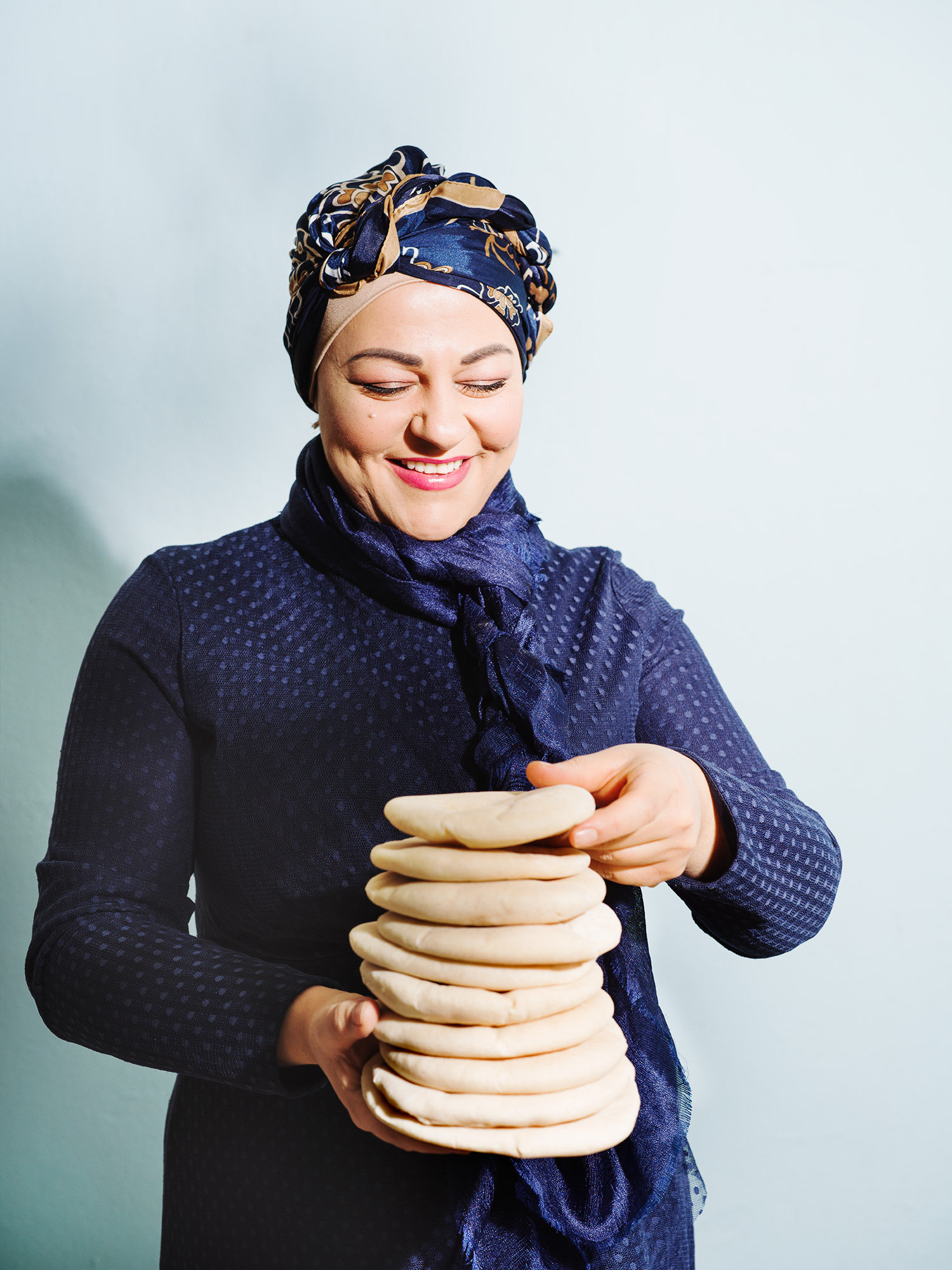 a woman holding a stack of dough