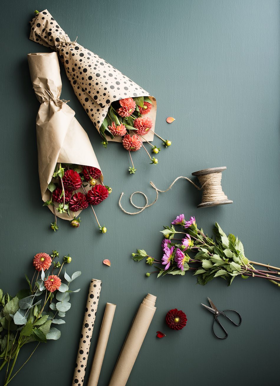flowers wrapped in paper next to scissors and paper