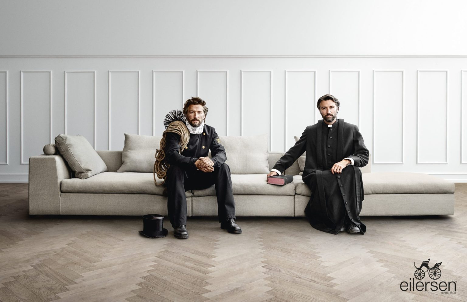 a man sitting on a couch with a man in a robe